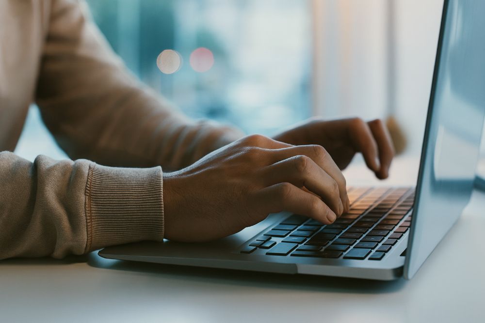 Hände tippen auf der Tastatur eines Laptops